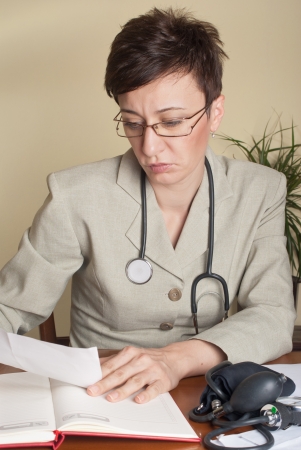 female doctor writing her diagnosisの写真素材