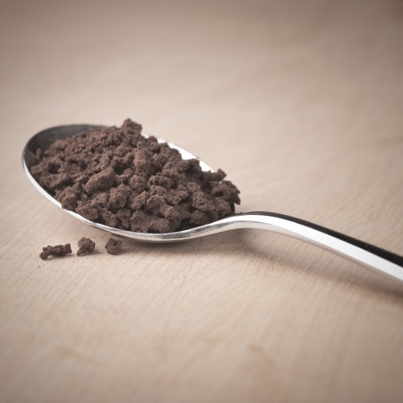 Instant coffee in the spoon on wooden tableの写真素材