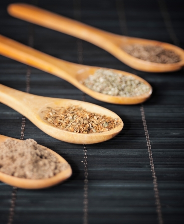 various spices in wooden spoons,focus on pizza spiceの写真素材