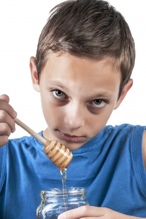 Boy tasting some honey,close upの写真素材
