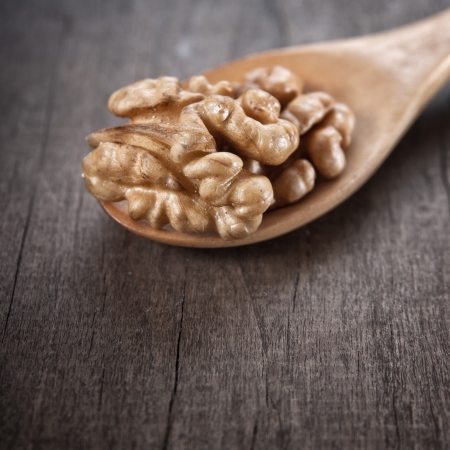 walnut in wooden spoon on wooden tableの写真素材