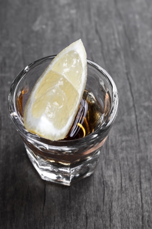 Single glass of tequila with lemon on tableの写真素材