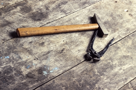 old hammer and pliers resting on tableの写真素材