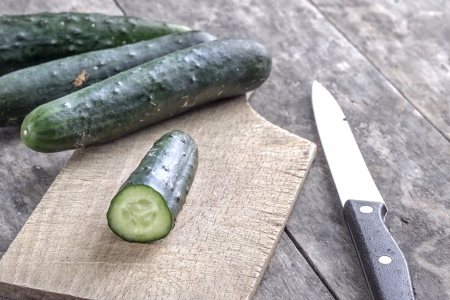 fresh cucumber on cutting board in close upの写真素材