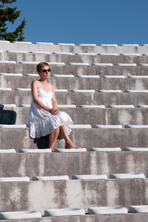 beautiful woman in white dress  looking to townの写真素材