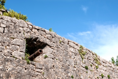 Stronghold stone wall with cannon in embrasureの写真素材