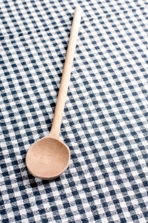 wooden spoon on a checkered tablecloth, close upの写真素材