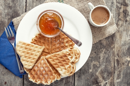 Breakfast with waffles, jam and coffee on the tableの写真素材