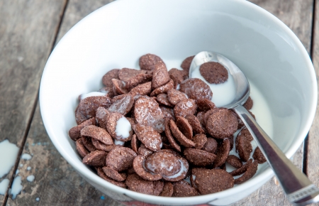	Several brown chocolate corn flakes in milk, detail photo