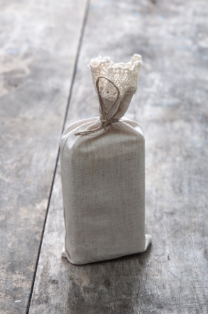  gift in jute bag on wooden background, backlitの写真素材