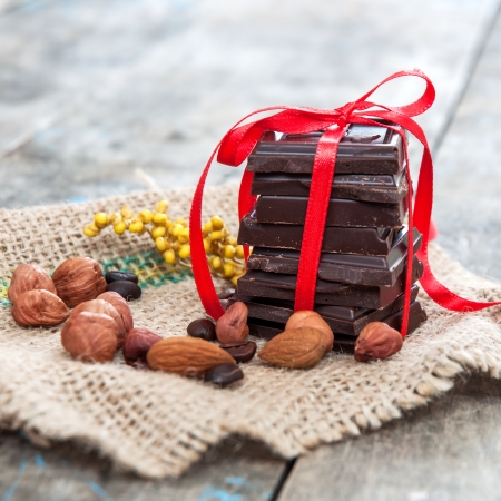 Chocolate pieces in decorative ribbon on wooden tableの写真素材