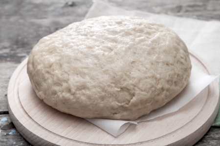 Dough for bread on a cutting wooden boardの写真素材