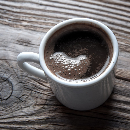 white coffee cup on wooden table, backlitの写真素材