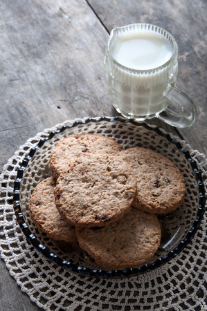 chocolate chip cookies and milk on wooden tableの写真素材