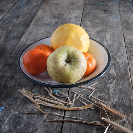 fresh fruit on a plate over wooden backgroundの写真素材