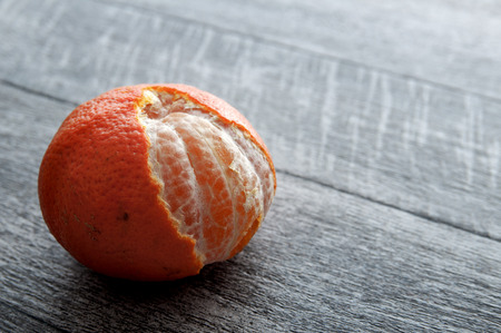 freshly peeled tangerine/orange on a wooden tableの写真素材
