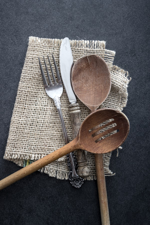 A mess of silver cutlery on a rustic backgroundの写真素材