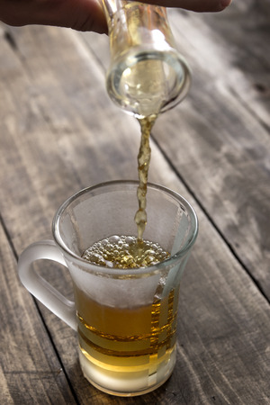 woman pouring freshly infused ironwort tea (sideritis syriaca) into a glassの写真素材