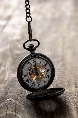 pocket watch over grunge wooden table, close upの写真素材