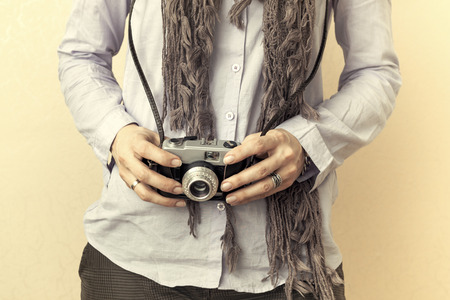 Close up of woman hand holding retro camera, sepiaの写真素材