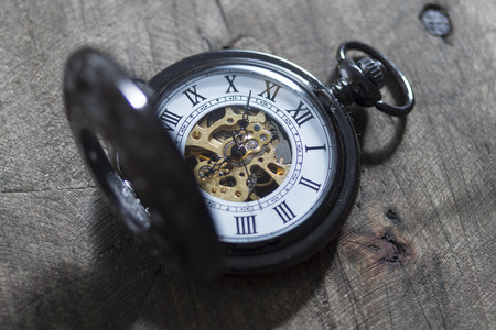 old vintage pocket watch lying on  wooden background