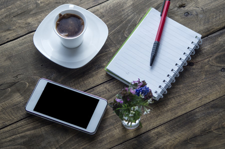 Coffee cup with phone and notebook on Working deskの写真素材