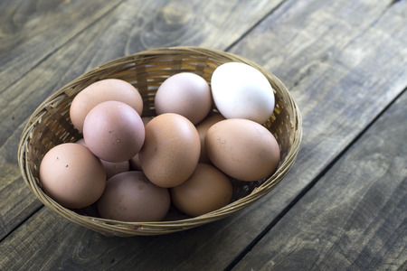 organic eggs in basket on wooden table