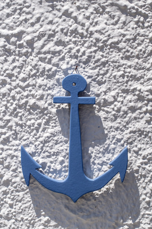 blue water anchor on the white wall, sunlightの写真素材