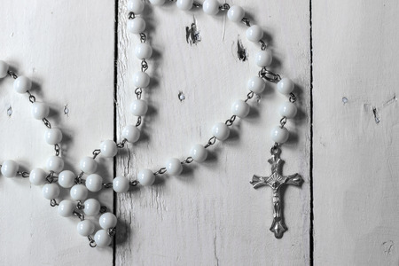 Rosary on rustic wooden surface, natural lightの写真素材