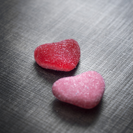 Candy in shape of hearts on wooden background. Close up