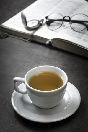 Cup of tea and book on wooden table, close upの写真素材