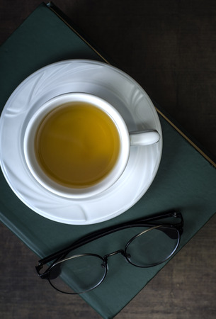 Cup of tea and book on wooden table, from aboveの写真素材
