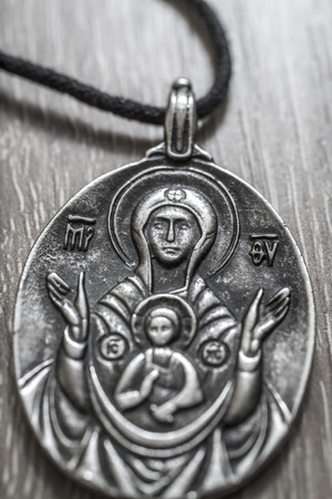 Virgin Mary Pendant on rustic wooden backgroundの写真素材