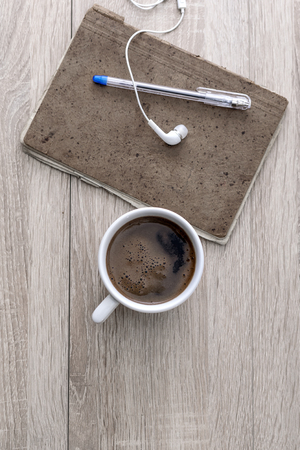 Coffee, notepad, earphones and pencil, on the office desk.の写真素材