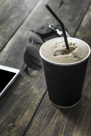 Cup of  coffee drink with sunglasses and mobile phone on wooden  tableの写真素材