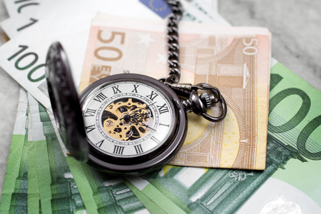 Time is money concept with euro banknotes and pocket watchの写真素材