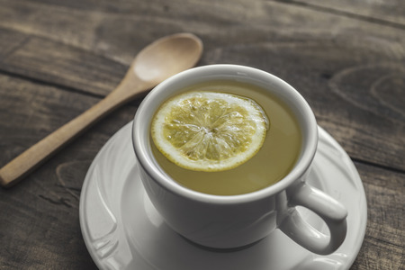Tea cup with lemon on wooden table, close upの写真素材
