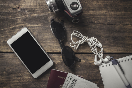 Preparation for travel, cellphone, sunglasses , passport  on wooden tableの写真素材