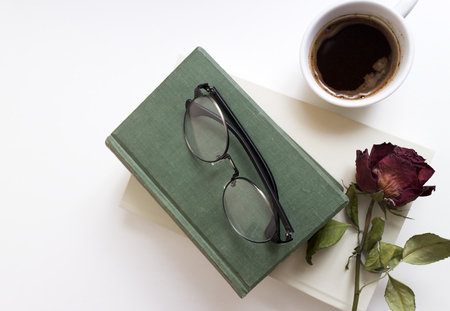 Cup of coffee with flower and books on wooden table, from aboveの写真素材