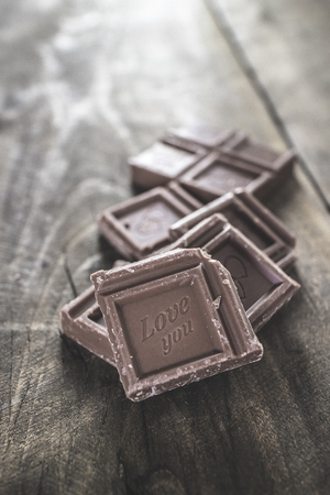 Pieces of  chocolate on wooden background, close upの写真素材