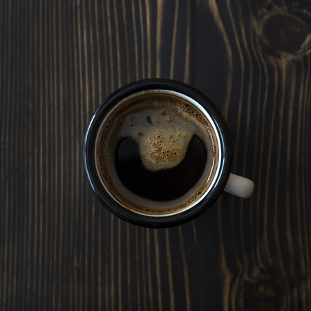Overhead view of a freshly brewed mug of black coffee on rustic wooden backgroundの写真素材