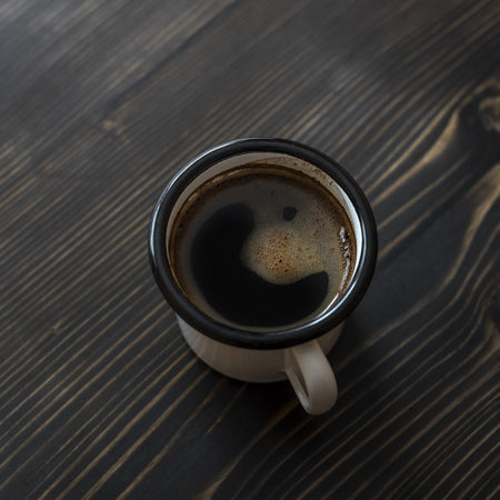 Overhead view of a freshly brewed mug of black coffee on rustic wooden backgroundの写真素材