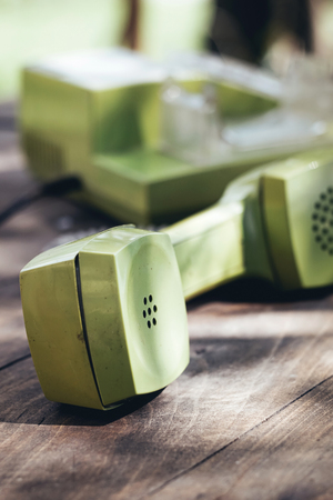 Green old-fashioned telephone on wooden background, close upの写真素材