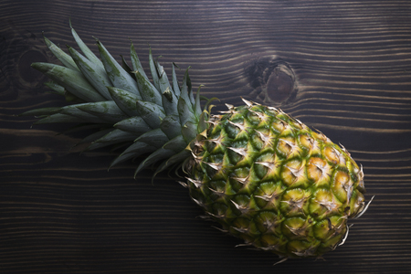 Ripe pineapple on a  wooden table, from aboveの写真素材