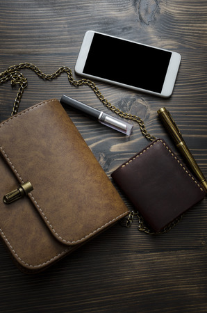 Contents of woman's bag on wooden background, from aboveの写真素材