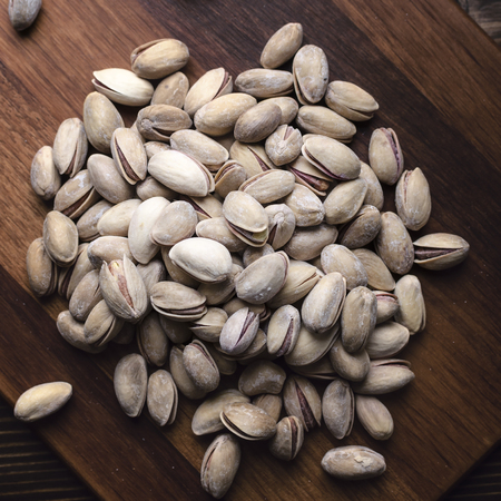 Delicious salted pistachios  on wooden background, from aboveの写真素材