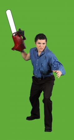 A psycho chainsaw murderer ready to attack isolated on greenの写真素材