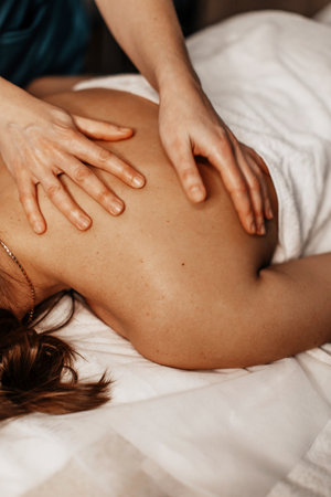 image of a womans hands doing a relaxing massage for a young girlの写真素材