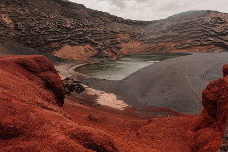 Volcanic Lanzarote island scenery. aerial panoramic drone view of Los Hervideros caves and cliffs and Red mountain . popular tourist destination Canary islandsの写真素材