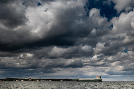 The dark sky with heavy clouds converging and a violent storm before the rain. Bad or moody weather sky and environment.の写真素材